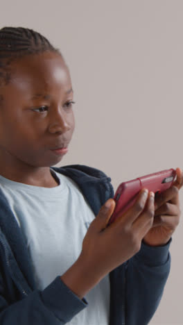 Vertical-Video-Of-Excited-Boy-On-ASD-Spectrum-Gaming-On-Mobile-Phone-On-White-Background